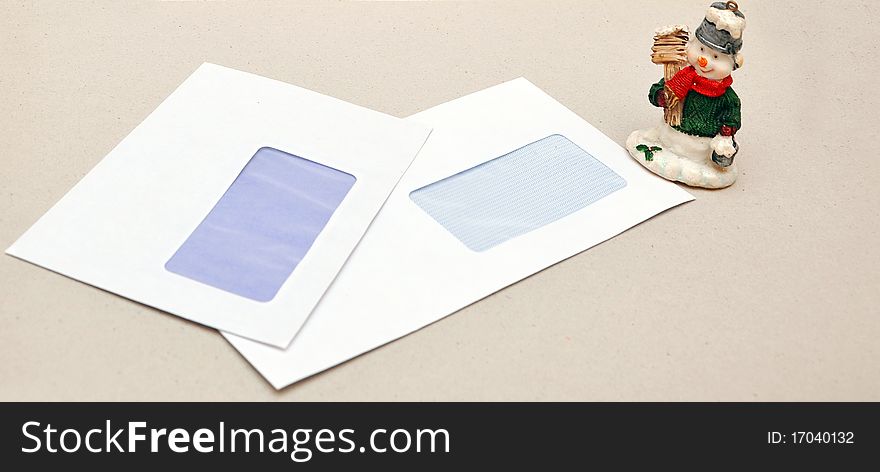 Christmas toy snowman on a background of empty envelopes. Christmas toy snowman on a background of empty envelopes