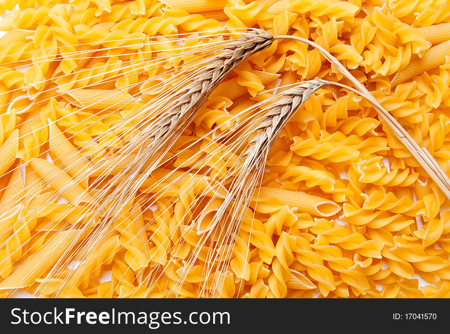 Two ears of wheat on a pasta background. Two ears of wheat on a pasta background