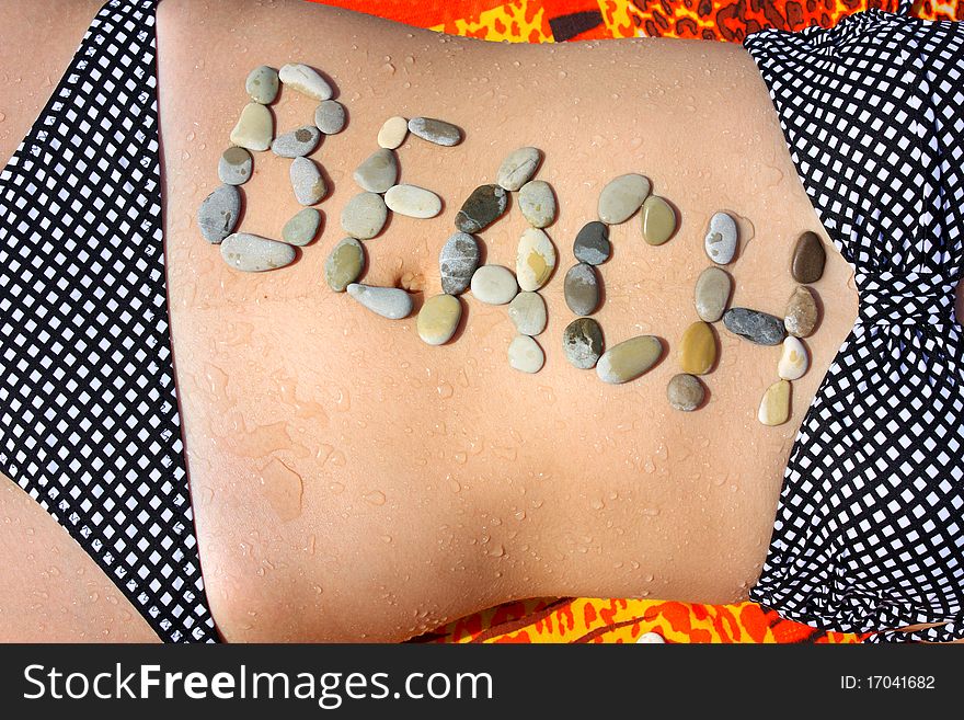 The word beach is stated by stones on a abdomen