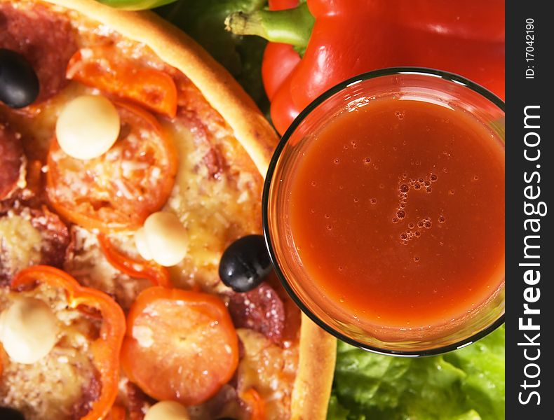 Closeup picture of a pizza with vegetables and glass of tomato juice. Closeup picture of a pizza with vegetables and glass of tomato juice