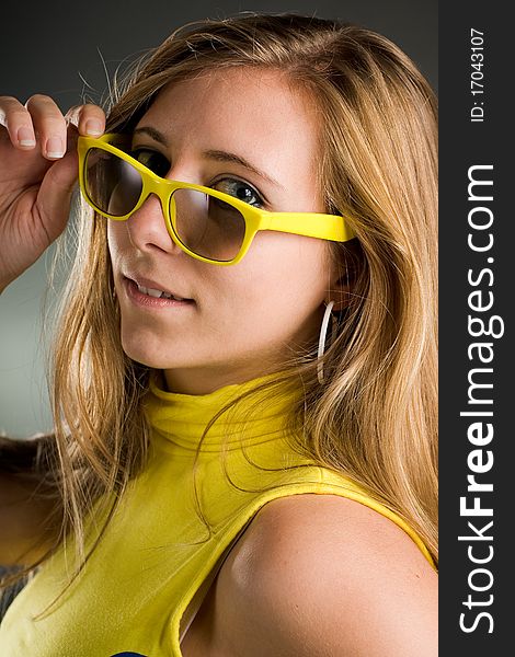 Beautiful portrait of a woman with yellow sunglasses in the studio. Beautiful portrait of a woman with yellow sunglasses in the studio