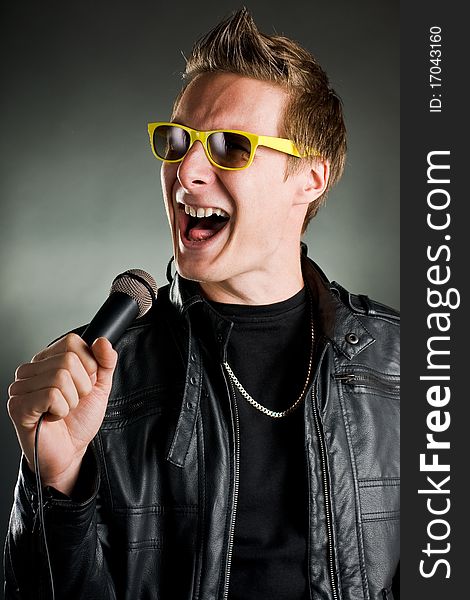 Rockstar sings with yellow sunglasses and leather jacket. Rockstar sings with yellow sunglasses and leather jacket