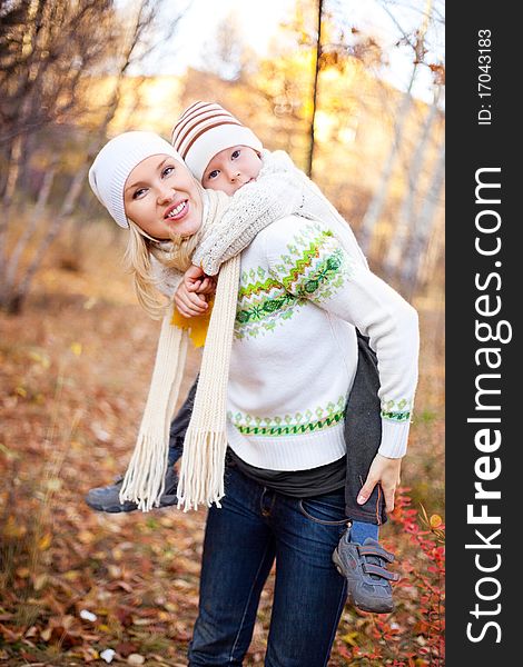 Happy young mother and her son spending time outdoor in the park. Happy young mother and her son spending time outdoor in the park