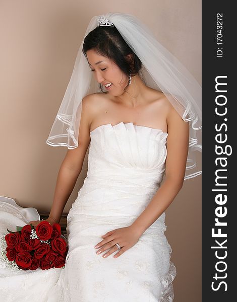 Beautiful bride wearing a traditional gown with red roses