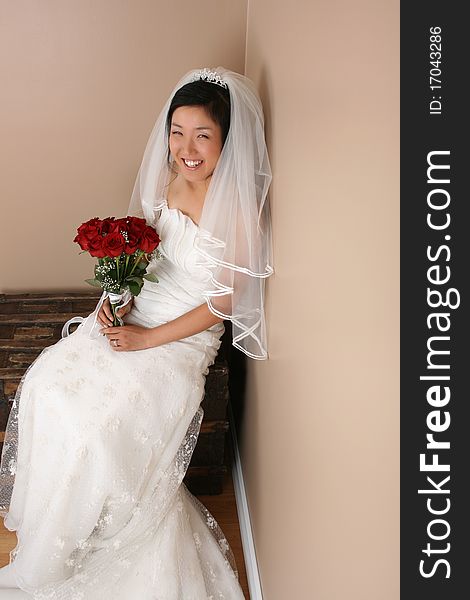 Beautiful bride wearing a traditional gown with red roses