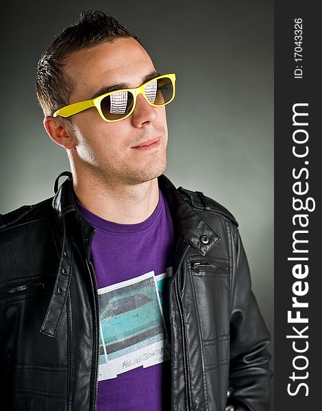 Attractive man with yellow sunglasses and leather jacket