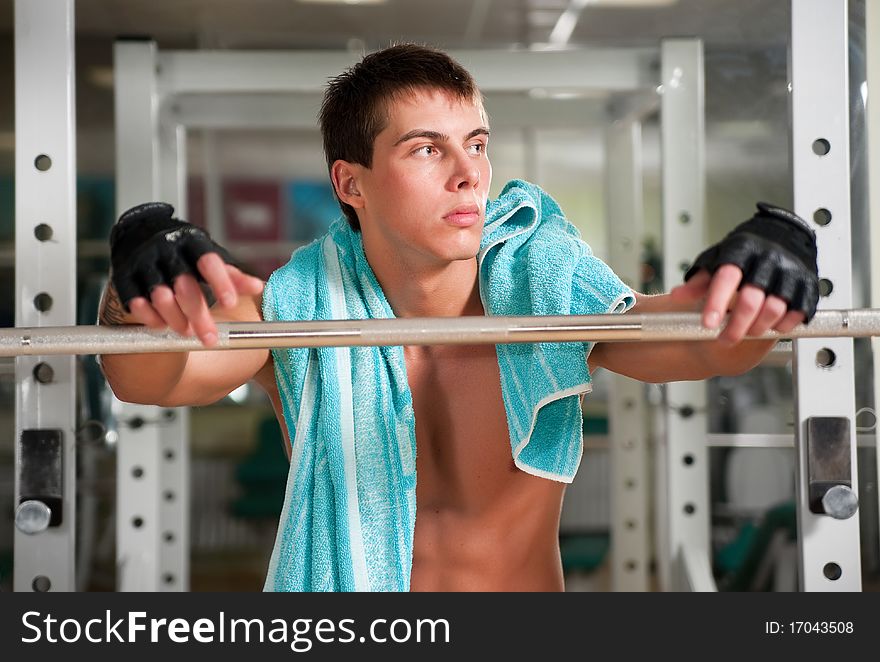 Muscular man working with heavy rod
