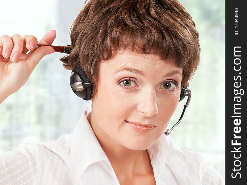 Portrait of a friendly woman with headset at her office. Portrait of a friendly woman with headset at her office