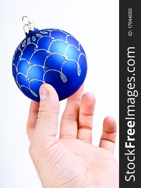 Hand holding a blue christmas ball on white