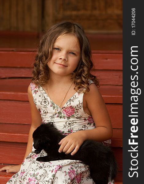 Little smiling girl holding cute black puppy. Little smiling girl holding cute black puppy.