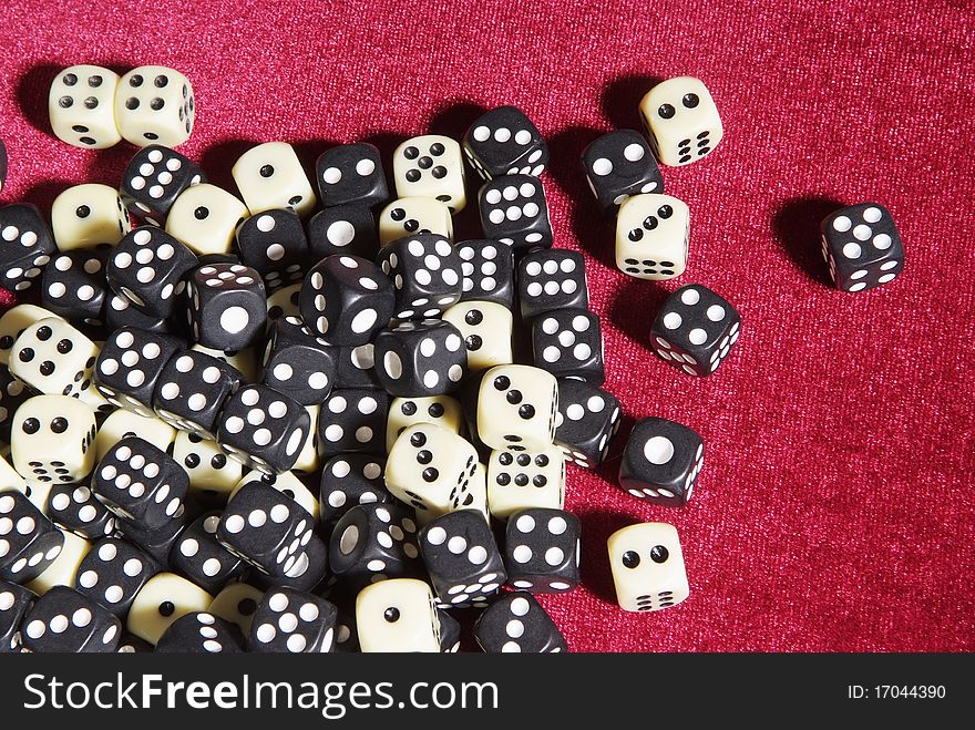 Dices on the red velvet, many white and black cubes