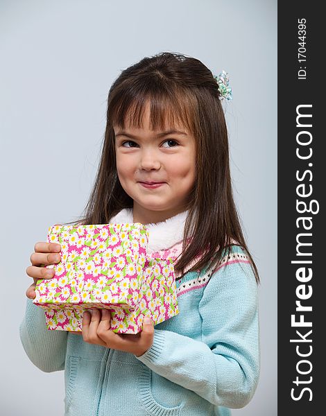 Cute little girl opening a gift box indoors. Cute little girl opening a gift box indoors