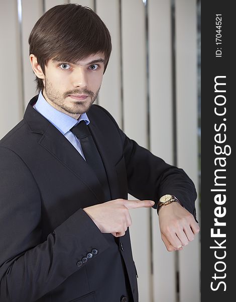 Businessman pointing to his watch with a finger. Businessman pointing to his watch with a finger