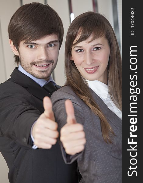 Businesswoman and businessman holding their hands in sign - thumbs up