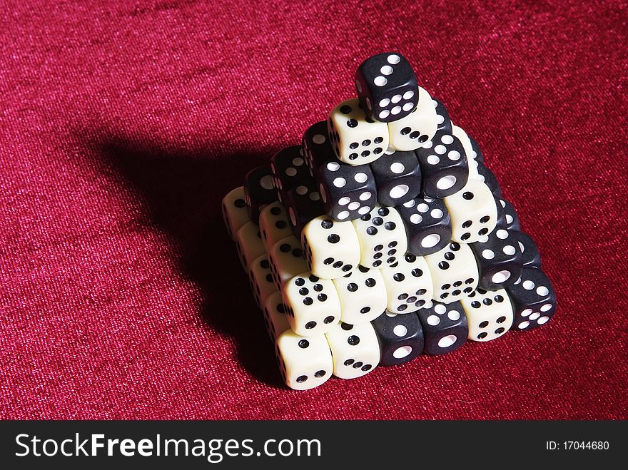 Pyramid of the dice on the red velvet, black and white cubes pyramid