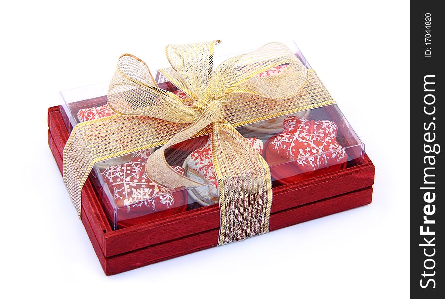 The red wooden box with multi-colored candles is packed by a tape. The red wooden box with multi-colored candles is packed by a tape