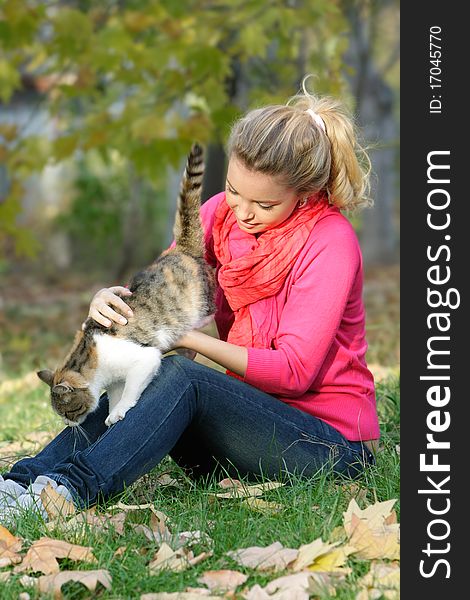 Attractive young girl with cat outdoors