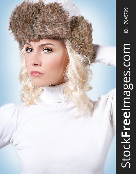 Headshot of the beautiful woman in the warm winter faux fur hat. Headshot of the beautiful woman in the warm winter faux fur hat