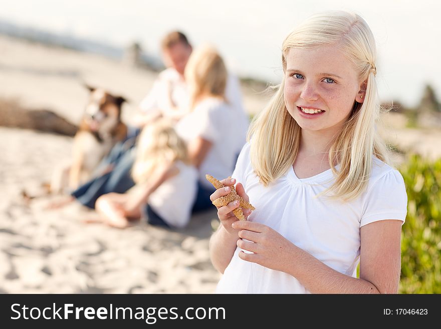 Adorable Little Blonde Girl with Starfish at The Beach.