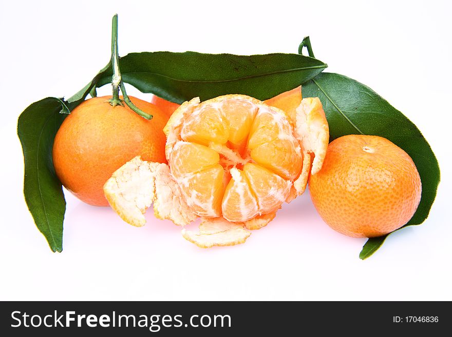 Mandarin oranges one partially peeled, on white background