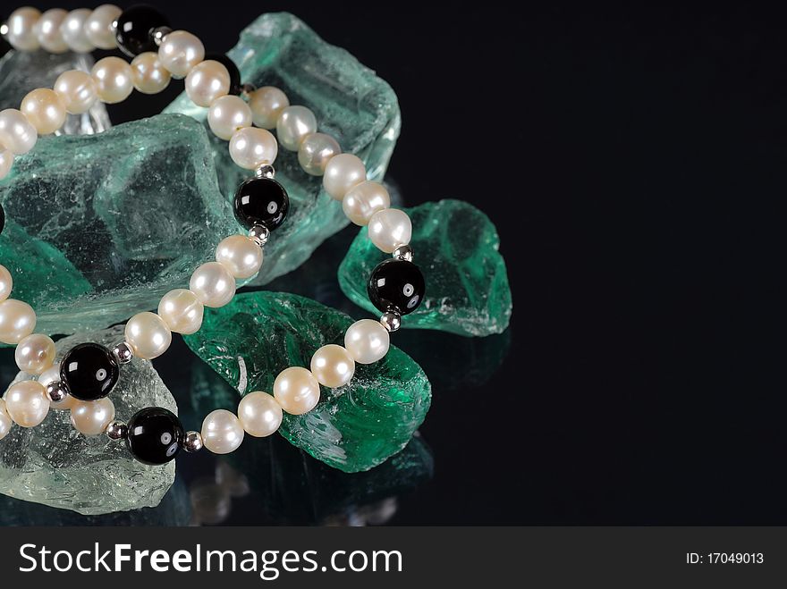Pearl necklace on top of glass rocks. Pearl necklace on top of glass rocks
