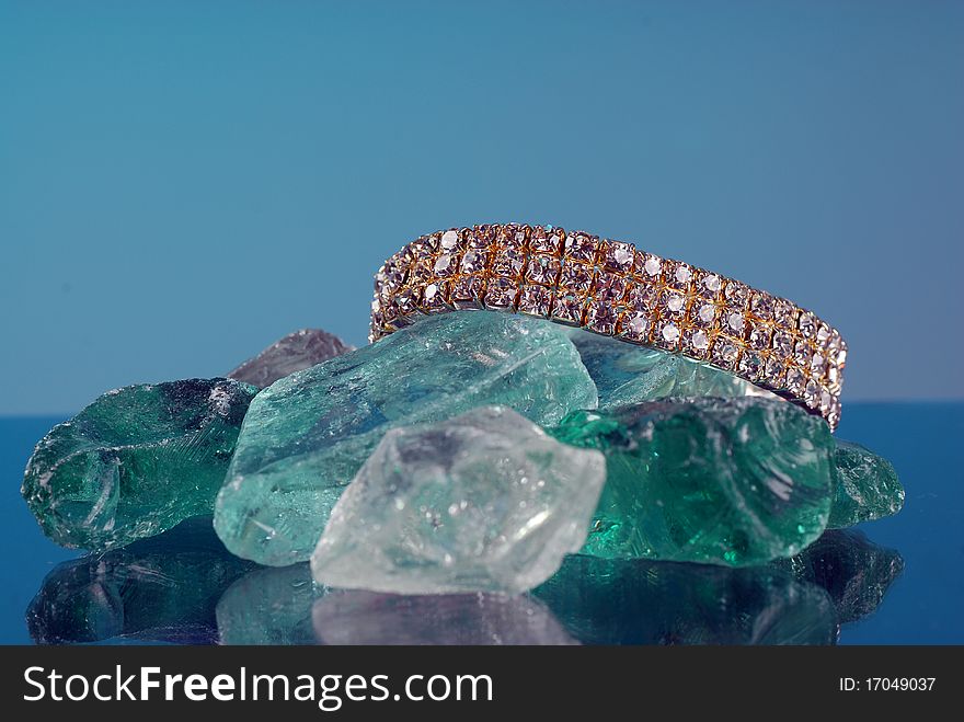 Fancy diamond braclet sitting on colored glass. Fancy diamond braclet sitting on colored glass