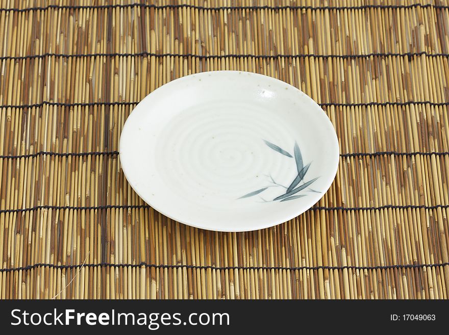 A bamboo paint asian dish on bamboo mattress. A bamboo paint asian dish on bamboo mattress