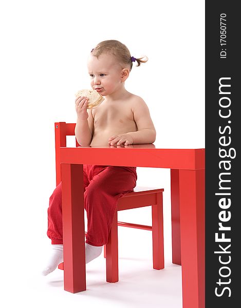Little Baby Girl Is Sitting On The Red Chair