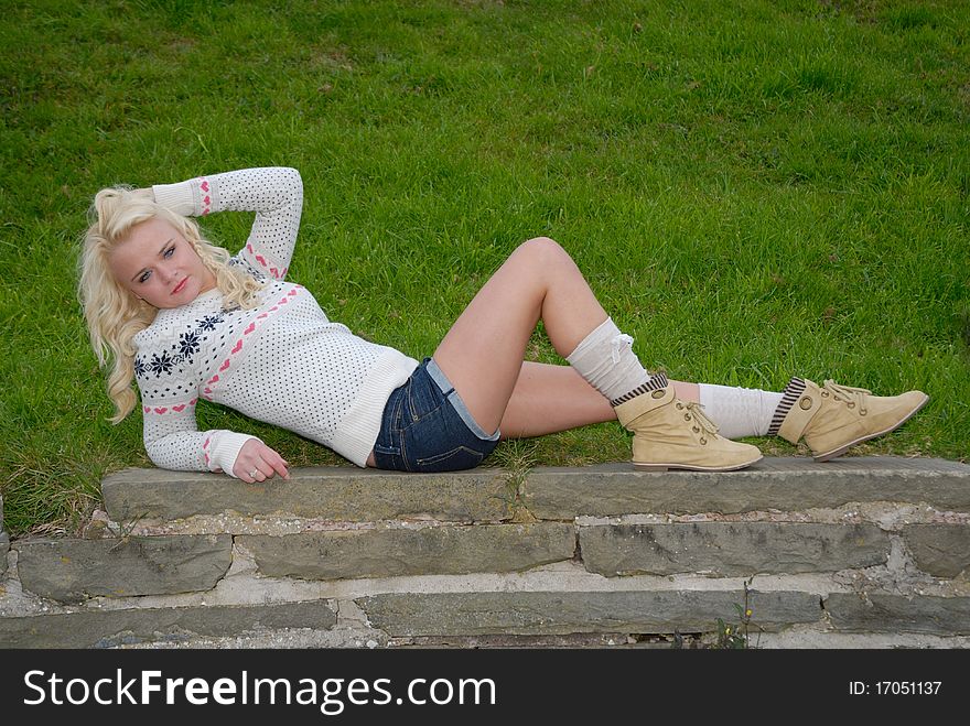 Photograph of retro looking young blond relaxing on wall. Photograph of retro looking young blond relaxing on wall