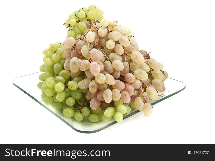 Green and pink grapes on a transparent plate on a white background. Green and pink grapes on a transparent plate on a white background.