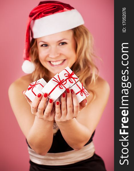 Winter portrait of a beautiful young smiling woman with a gift in her hands