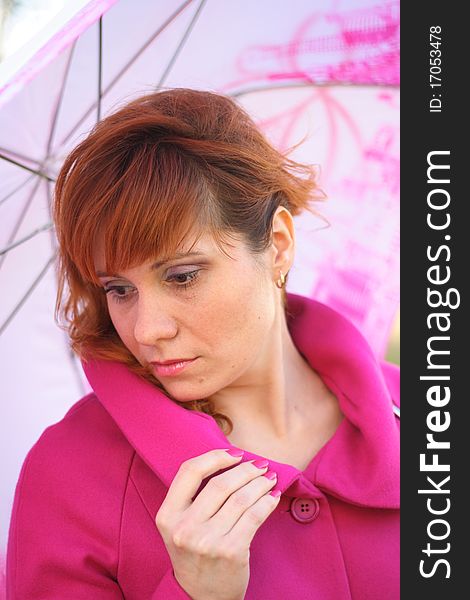 A young woman under a pink umbrella. A young woman under a pink umbrella