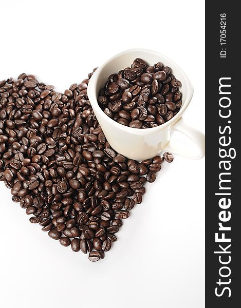 Coffee beans in a cup with heart shape of coffee beans