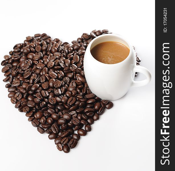 Coffee beans in a cup with heart shape of coffee beans