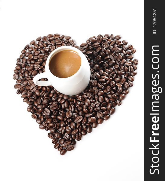 Coffee beans in a cup with heart shape of coffee beans