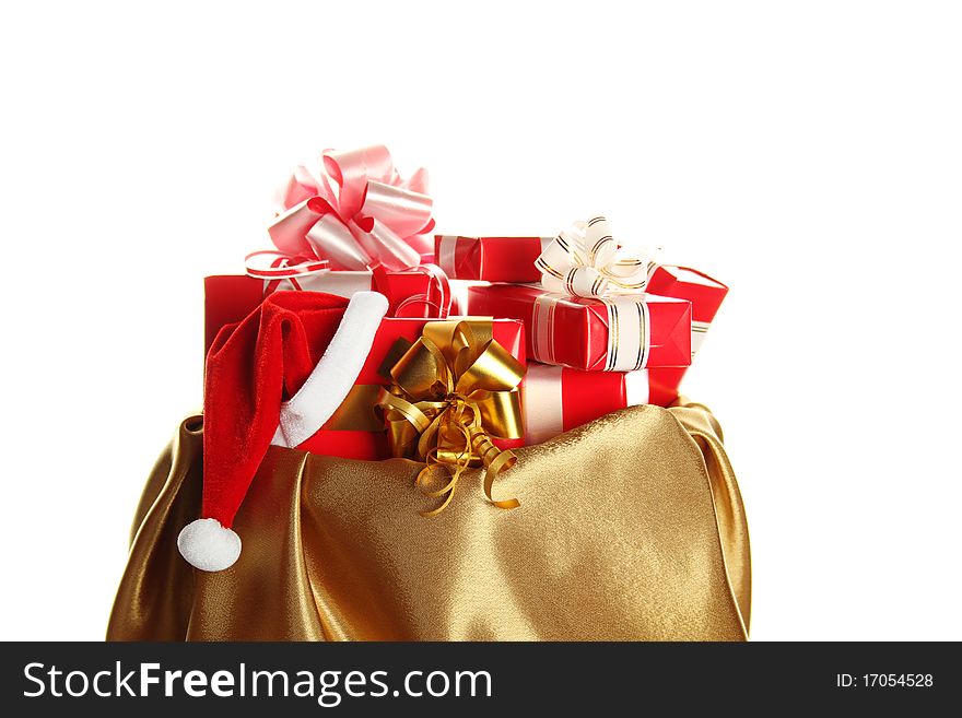 Sack of gold color filled to the brim with Christmas gifts. At one gift Santa's wearing a cap. Isolated on a white background. Sack of gold color filled to the brim with Christmas gifts. At one gift Santa's wearing a cap. Isolated on a white background