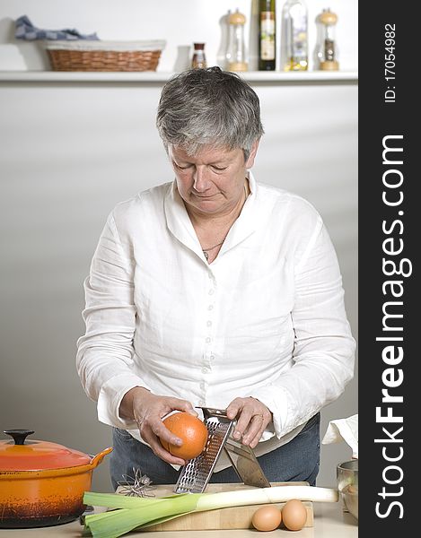 Women is using a grater in the kitchen