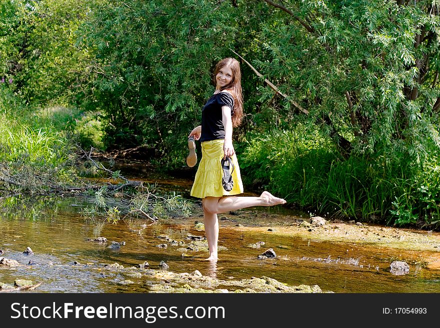 Young woman crossing little stream in forest. Young woman crossing little stream in forest