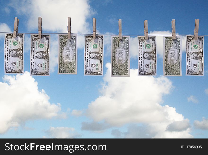1 dollar bills hanging on a clothes line with clouds on background. 1 dollar bills hanging on a clothes line with clouds on background