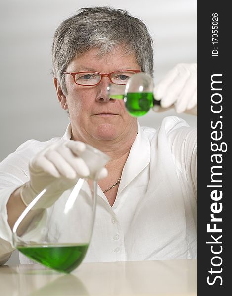 Scientist is working with a green liquid