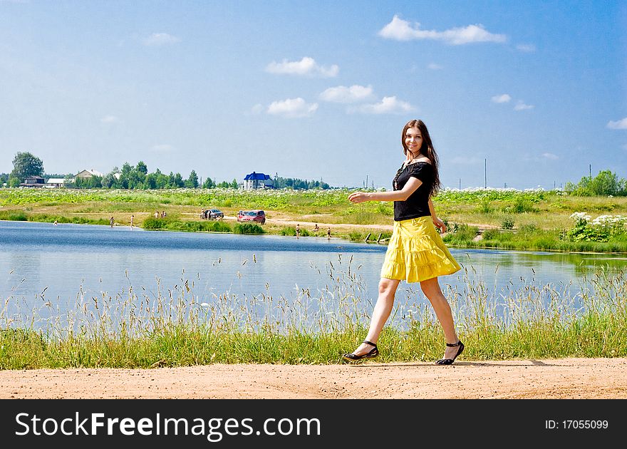 Woman walking near the lake on a sunny summer day. Woman walking near the lake on a sunny summer day