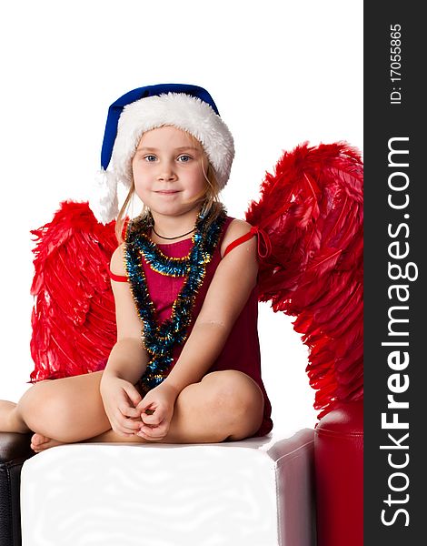 Girl in Santa's blue hat and tinsel with red angel's wings  isolated on white. Girl in Santa's blue hat and tinsel with red angel's wings  isolated on white