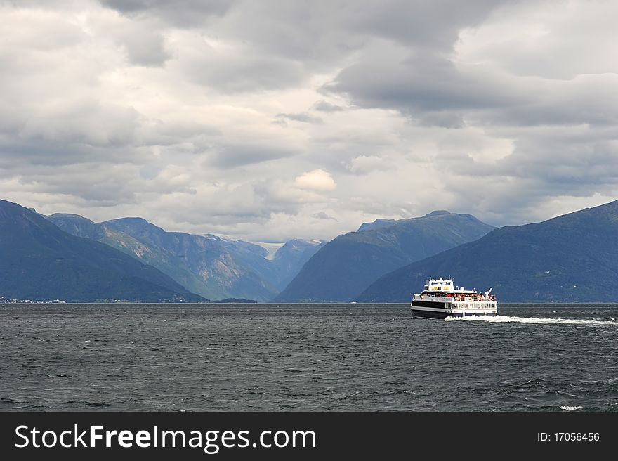 Classic cruise liner in Norwegian fjords in cloudy weather. Classic cruise liner in Norwegian fjords in cloudy weather