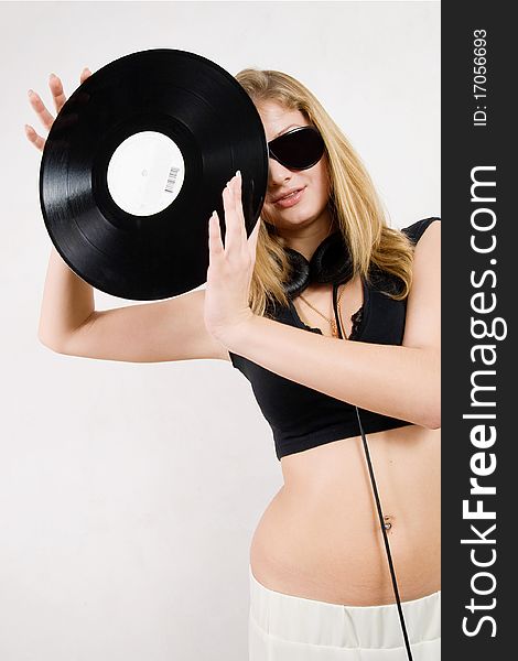 Blond girl in sunglasses and headphones posing. Blond girl in sunglasses and headphones posing