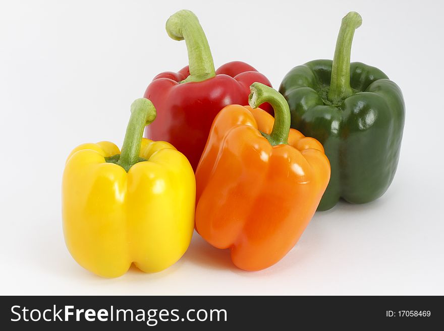 Studio shot, colored peppers in front of a white background