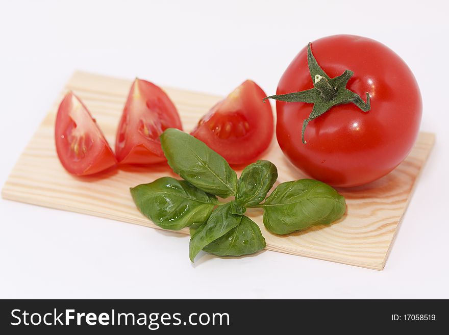 Studio shot, sliced tomato with basil in front of a white background