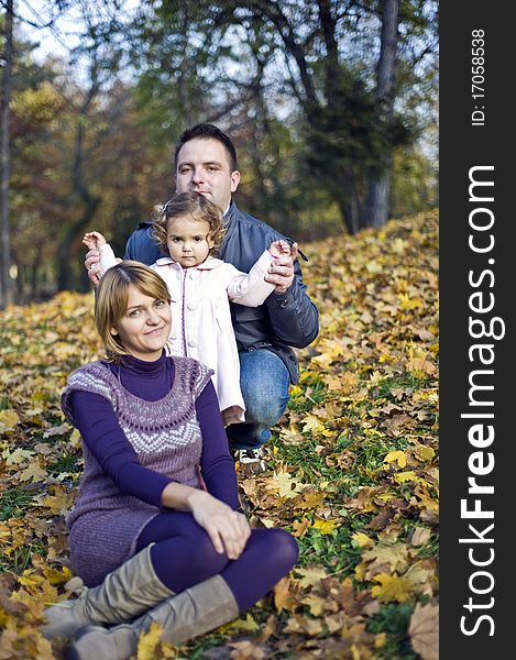 Happy family, mom, dad and little girl in the park in autumn. Happy family, mom, dad and little girl in the park in autumn