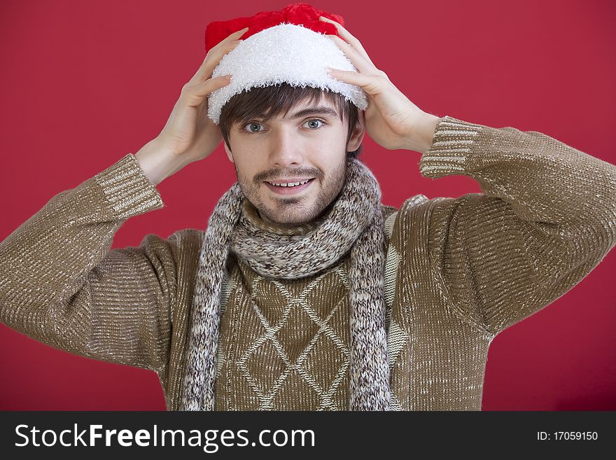 Portrait of happy young man in santa hat on red background. Portrait of happy young man in santa hat on red background