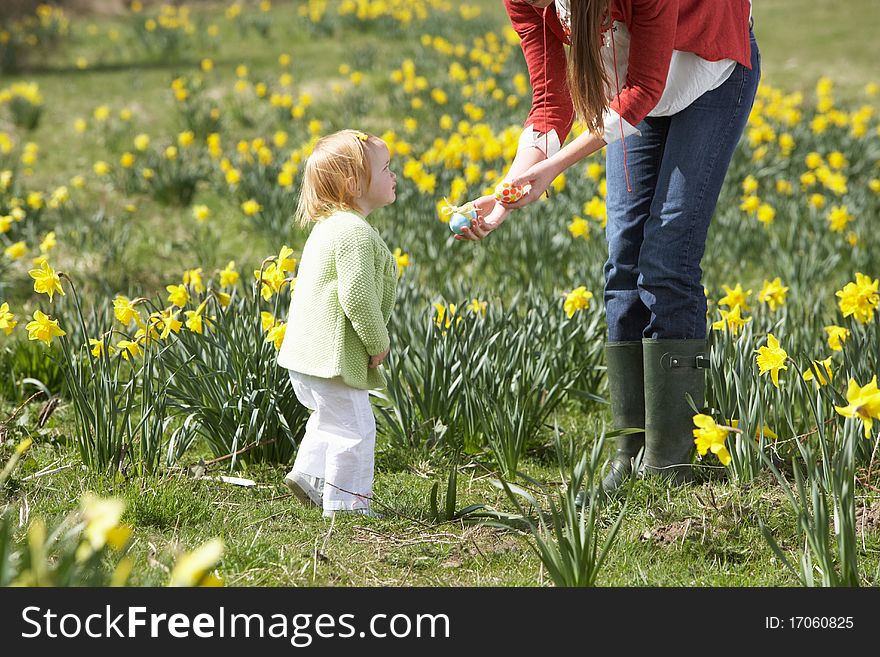 Mother And Daughter In Daffodil Field With Decorated Easter Eggs. Mother And Daughter In Daffodil Field With Decorated Easter Eggs