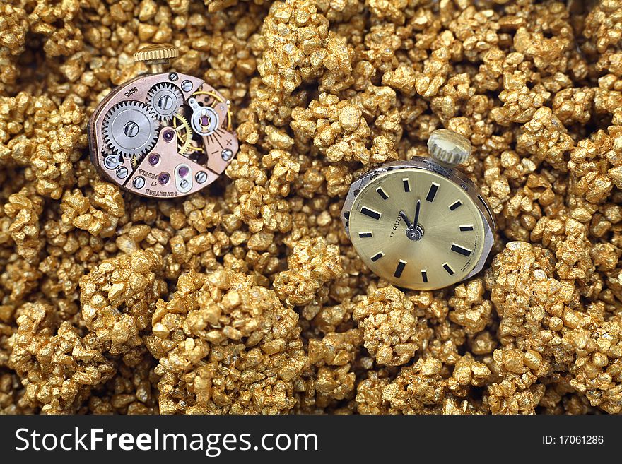 The mechanism of analog watch on the golden sand closeup